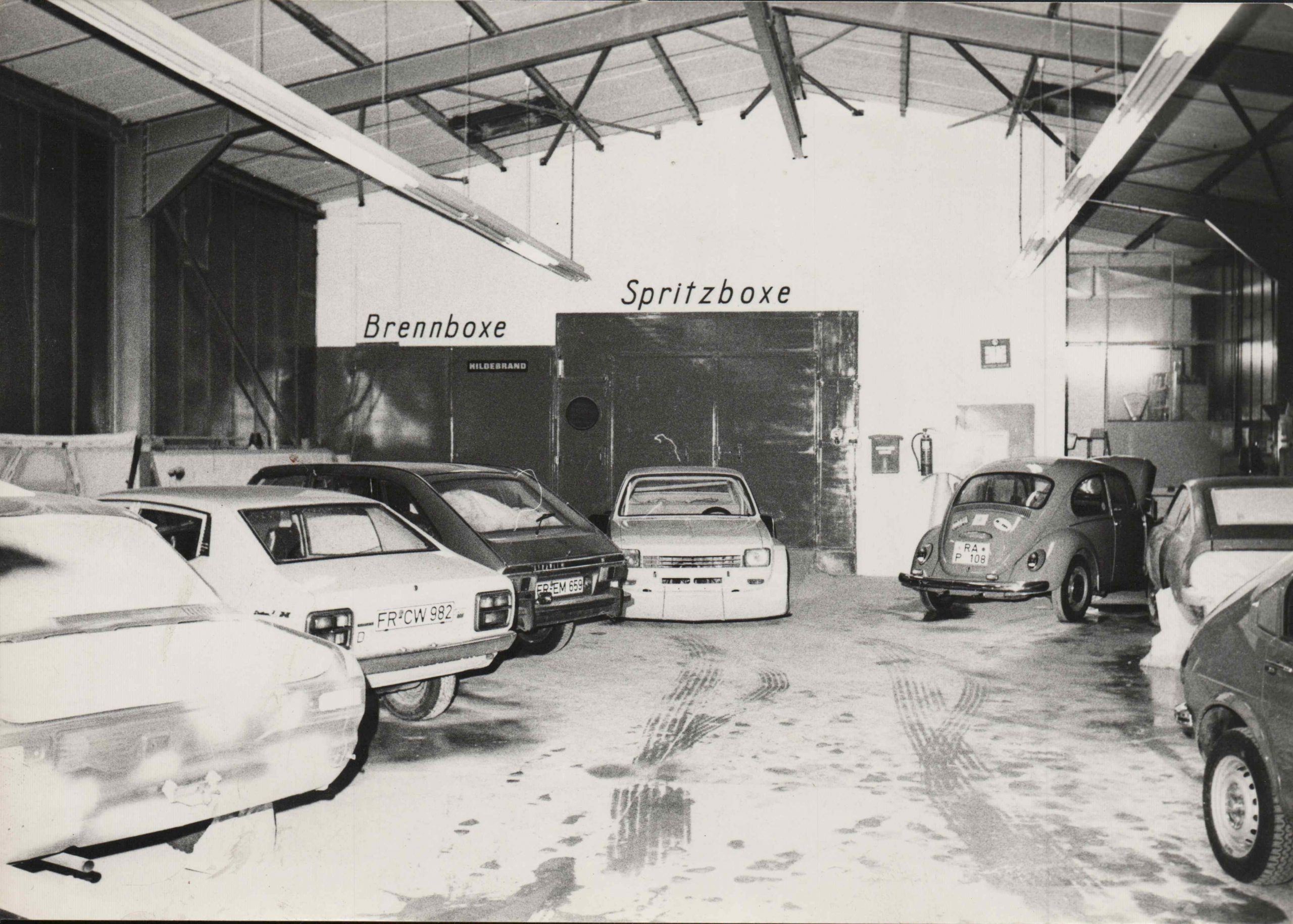 Historische Aufnahme der Lackierhalle mit Brennboxe und Spritzboxe, mehrere Fahrzeuge aus den 1990er Jahren